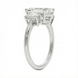 Detailed side view showing the architectural basket settings for the three-stone emerald ring.