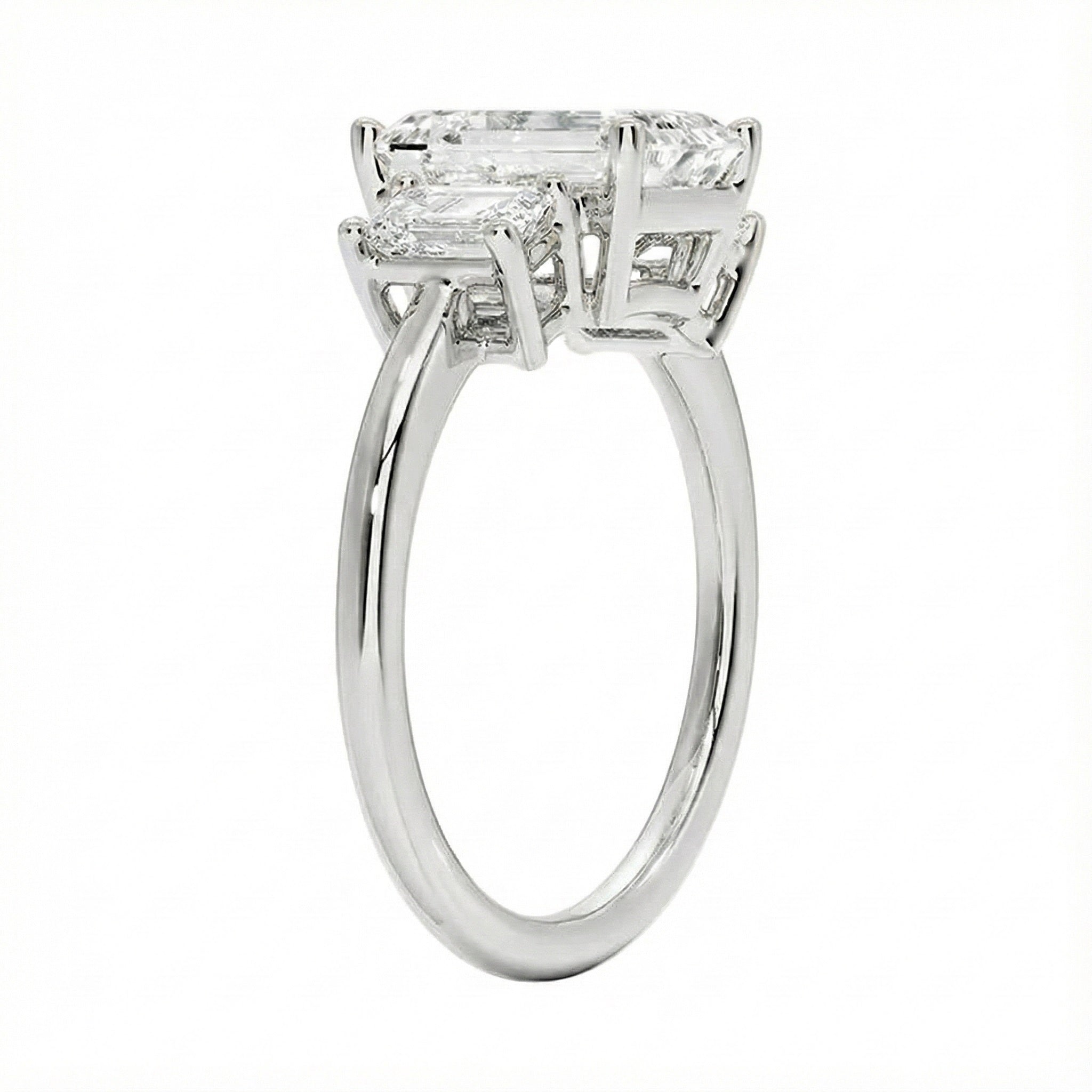 Detailed side view showing the architectural basket settings for the three-stone emerald ring.