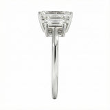 Symmetrical top-down view of a graduated triple emerald-cut moissanite ring in polished solid gold.