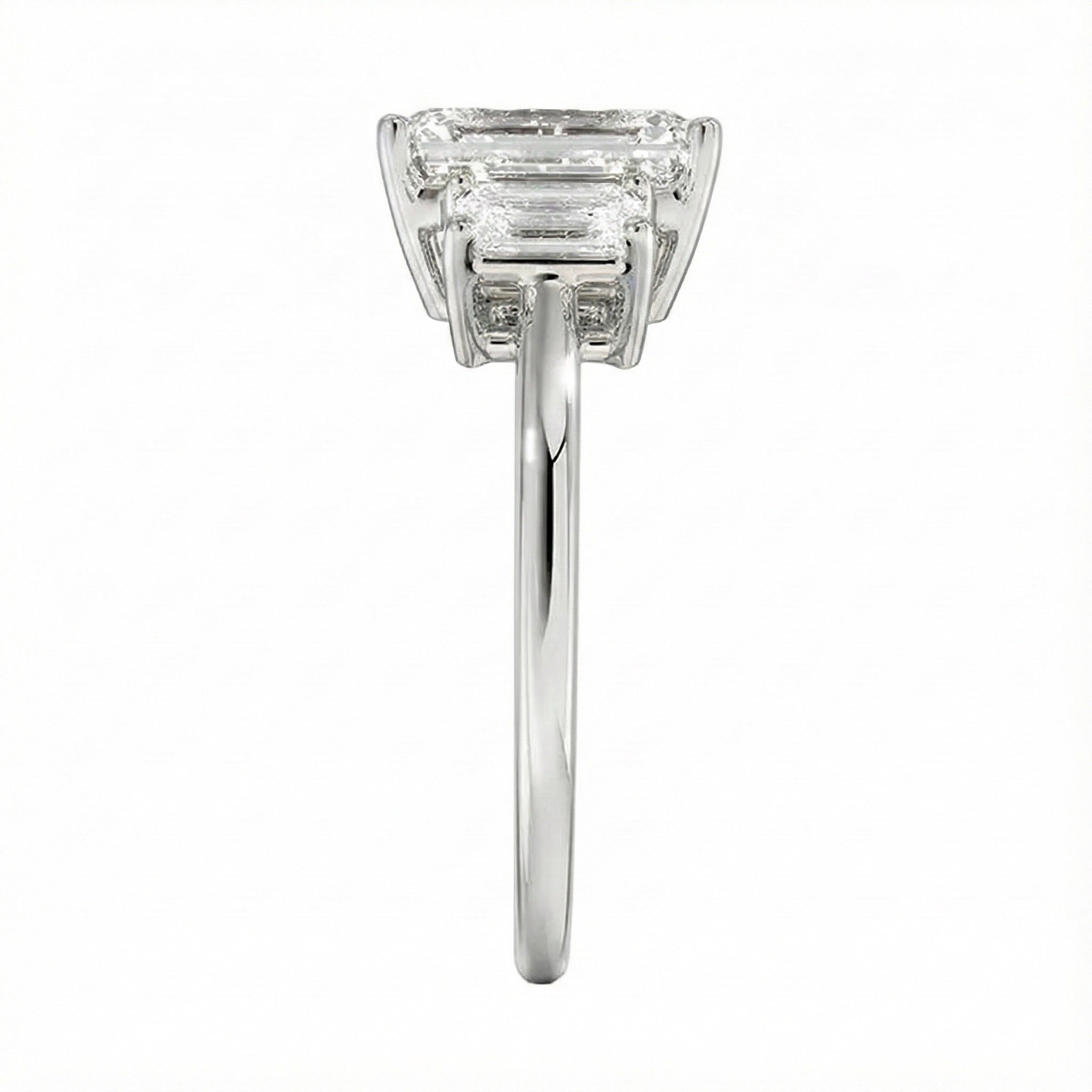 Symmetrical top-down view of a graduated triple emerald-cut moissanite ring in polished solid gold.