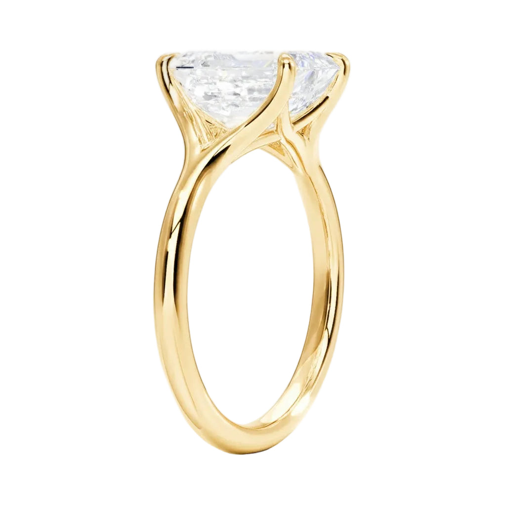 Detailed side view of an emerald moissanite ring showing the architectural split-shoulder design and cat-claw setting.