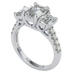 Top-down view of a D-color VVS1 graduated three-stone emerald moissanite ring with accent stones.