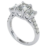 Top-down view of a D-color VVS1 graduated three-stone emerald moissanite ring with accent stones.