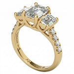 Top-down view of a D-color VVS1 graduated three-stone emerald moissanite ring with accent stones.