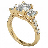 Top-down view of a D-color VVS1 graduated three-stone emerald moissanite ring with accent stones.