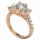 Top-down view of a D-color VVS1 graduated three-stone emerald moissanite ring with accent stones.
