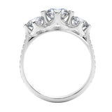 Top-down view of a D-color VVS1 graduated three-stone round moissanite ring with accent stones.
