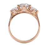 Top-down view of a D-color VVS1 graduated three-stone round moissanite ring with accent stones.