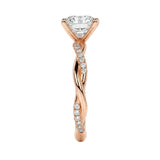Elegant infinity twist engagement ring on a finger showing the delicate sparkle and polished gold finish.