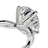 Detailed side view of an infinity twist ring showing the intertwined shank and professional four-prong setting.
