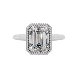 alt="An Emarald cut Moissanite engagement ring round shank with a bezel setting, on a gold band, against a white background.Moissanite engagement ring cape town south africa grand diamonds ralph jacobs jeulia 