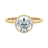 Round cut Moissanite lab grown diamond engagement ring round shank with a bezel setting, on a gold band, against a white background.Moissanite engagement ring cape town south africa grand diamonds ralph jacobs jeulia 