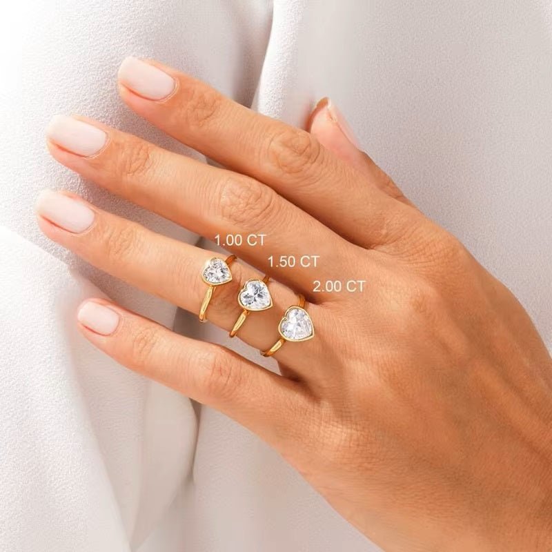  Heart shape Moissanite lab grown diamond engagement ring round shank with a bezel setting, on a gold band, against a white background.Moissanite engagement ring cape town south africa grand diamonds ralph jacobs jeulia 