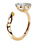 Close-up of a high-quality D-color VVS1 oval moissanite center stone on an artistic yellow gold band.
