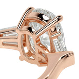 Rose gold ring with a large diamond and smaller baguette-cut diamonds on a white background