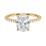 Dainty four-claw oval moissanite ring with hidden halo and encrusted prongs in yellow gold ApolloGem.
