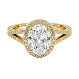 A halo oval-cut engagement ring with a unique V-band and pave, featuring a central oval-shaped moissanite stone surrounded by smaller stones set in a gold band.