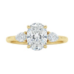 Luxury oval cut moissanite engagement ring in yellow gold with two elegant pear cut side stone accents ApolloGem South Africa.