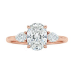 Detailed side view of an oval moissanite engagement ring showing the secure four-prong setting and teardrop pear-shaped side stones