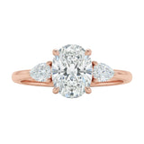Detailed side view of an oval moissanite engagement ring showing the secure four-prong setting and teardrop pear-shaped side stones