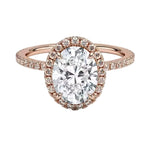 Rose gold ring with a large diamond and smaller diamonds around on a white background
