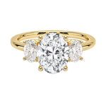 Oval brilliant cut moissanite trilogy engagement ring in yellow gold ApolloGem.