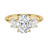 Oval brilliant cut moissanite trilogy engagement ring in yellow gold ApolloGem.