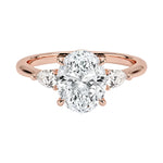 Rose gold ring with a large diamond and smaller diamonds on the sides against a white background