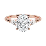 Rose gold ring with a large diamond and smaller diamonds on the sides against a white background