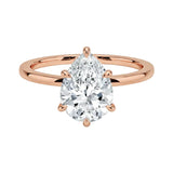 Close-up of a high-quality D-color VVS1 pear cut moissanite in a simple and elegant gold setting.