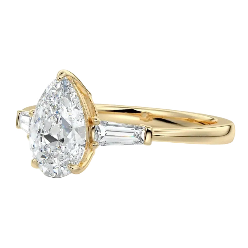 Detailed close-up of a GRI certified D-color VVS1 pear moissanite with crisp tapered baguette side stones in 18k gold.