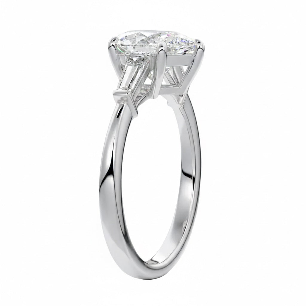 Top-down view of a symmetrical pear brilliant ring with tapered baguettes on a polished white gold shank.