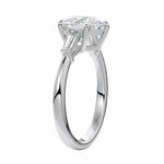 Top-down view of a symmetrical pear brilliant ring with tapered baguettes on a polished white gold shank.