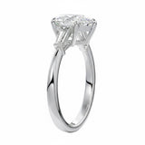 Top-down view of a symmetrical pear brilliant ring with tapered baguettes on a polished white gold shank.