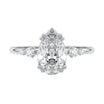 Detailed close-up of a D-color VVS1 pear moissanite with two small round brilliant accents on each side in 18k gold.