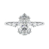 Detailed close-up of a D-color VVS1 pear moissanite with two small round brilliant accents on each side in 18k gold.