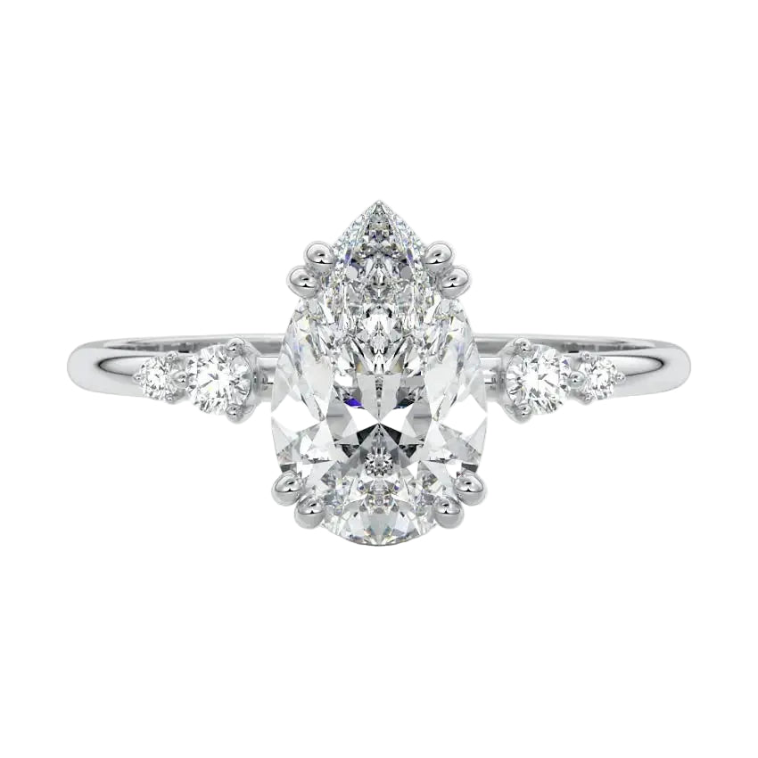 Detailed close-up of a D-color VVS1 pear moissanite with two small round brilliant accents on each side in 18k gold.