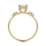 Macro view of an ultra-slim yellow gold wedding ring featuring a central pear moissanite and graduated round accents.