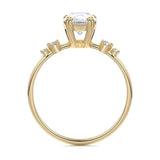 Macro view of an ultra-slim yellow gold wedding ring featuring a central pear moissanite and graduated round accents.