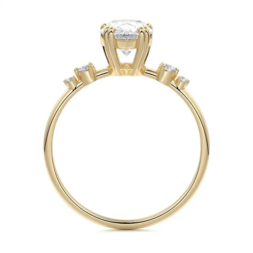 Macro view of an ultra-slim yellow gold wedding ring featuring a central pear moissanite and graduated round accents.