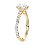  Top-down view of a D-color VVS1 round stone in a yellow gold six-prong cathedral setting.