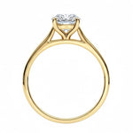 Symmetrical top-down view of a round moissanite solitaire in a polished yellow gold cathedral setting.