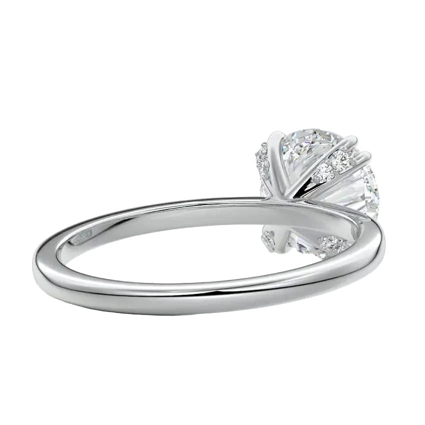 Close-up of a high-quality D-color VVS1 round moissanite secured by polished double cat-claw prongs.
