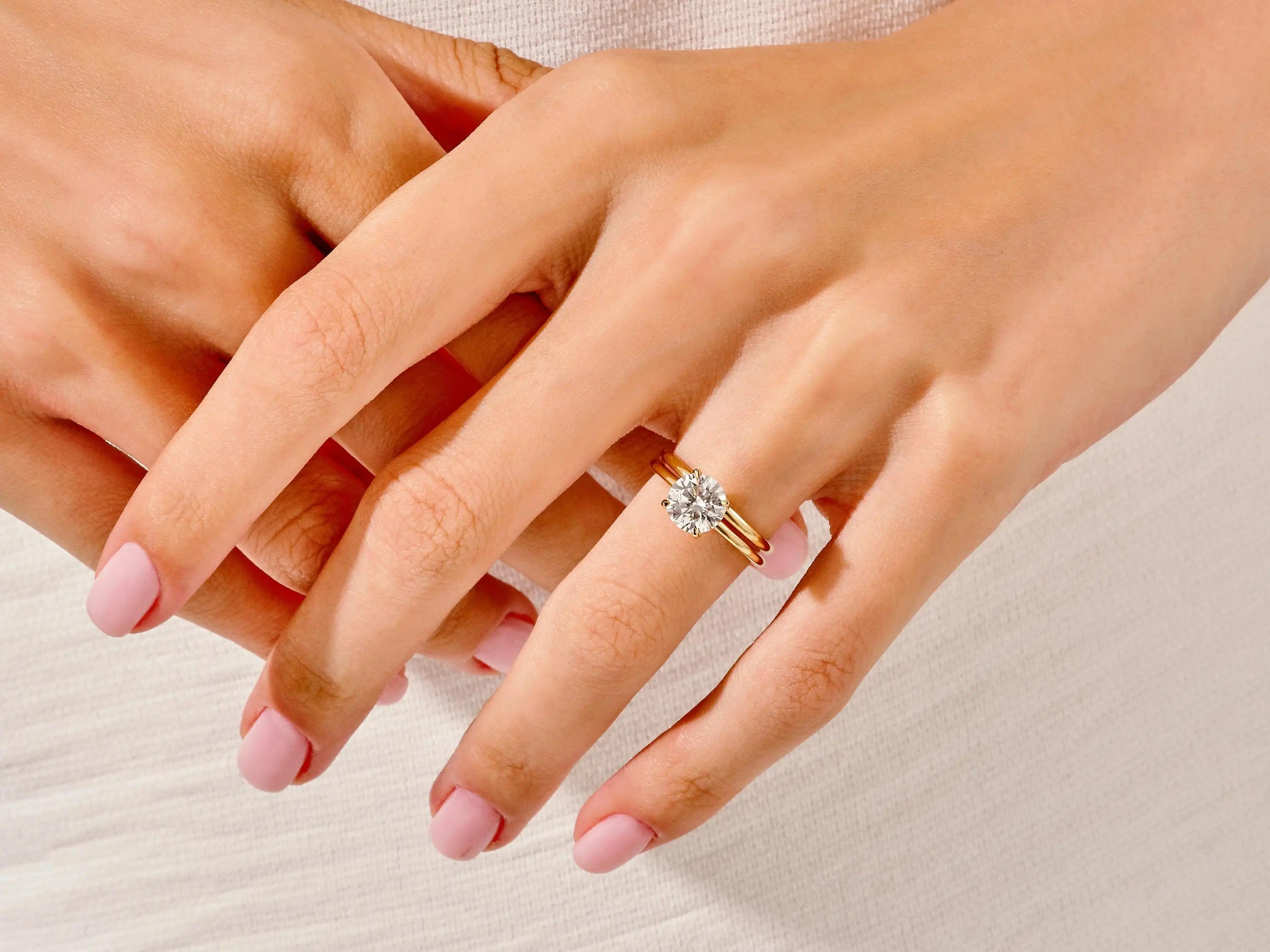 The Round Duo Essence set on a finger showing the elegant slim-line silhouette and brilliant fire.
