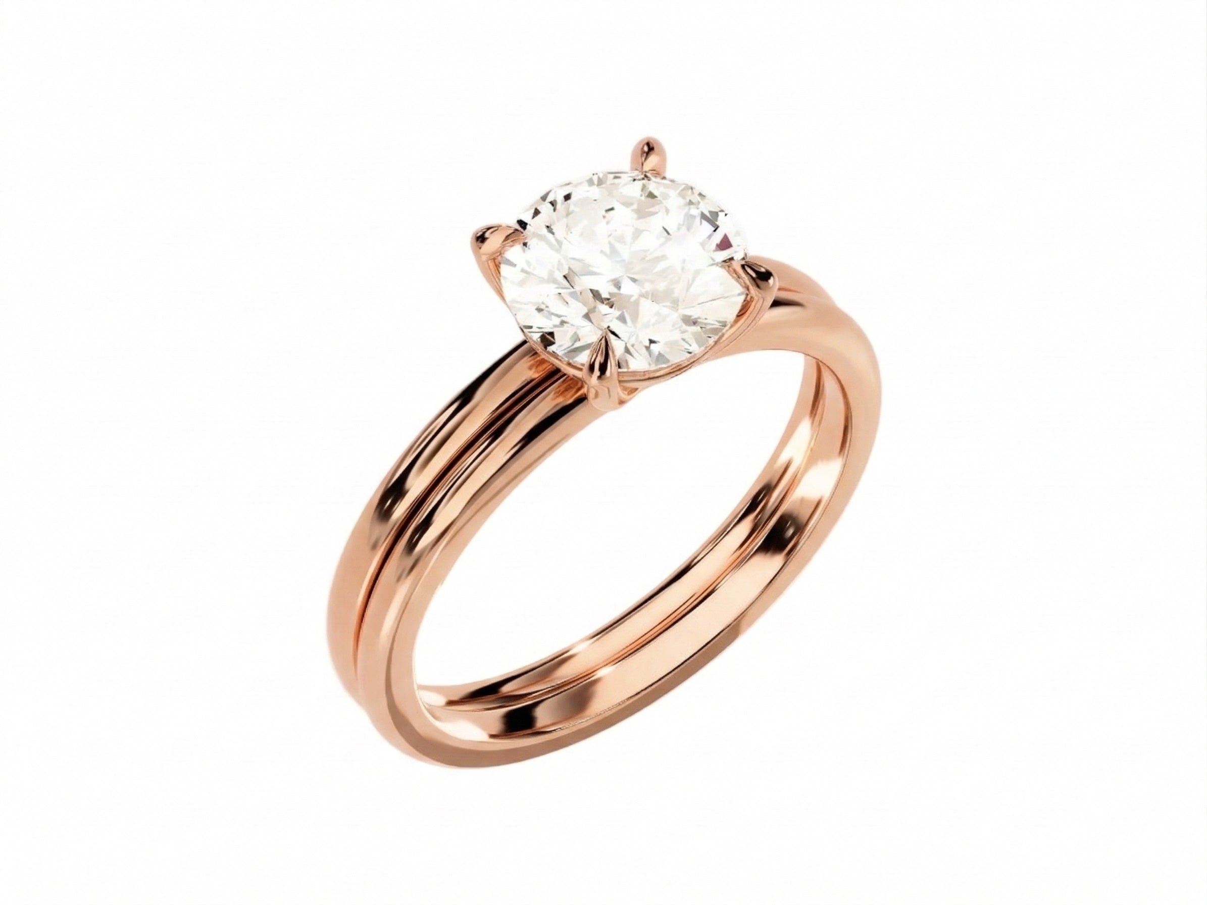 Four-prong round solitaire with a dainty polished shank and matching wedding ring in rose gold.