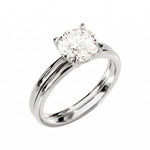 Four-prong round solitaire with a dainty polished shank and matching wedding ring in white gold.
