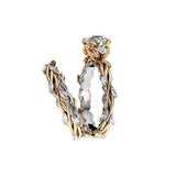 Round moissanite with symmetrical pear accents and a marquise interval wedding band in two-tone gold.