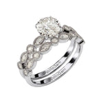 White gold moissanite bridal set with a round solitaire and matching vintage-style wedding band.