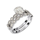 White gold moissanite bridal set with a round solitaire and matching vintage-style wedding band.