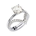 Four-prong round solitaire with decorative leaf-style shoulders and matching v-shaped band.
